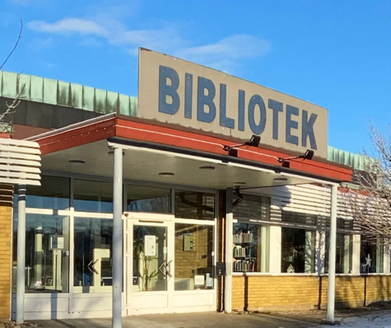 Bild på biblioteket i Bjuv med blå himmel och rosa blommor 
