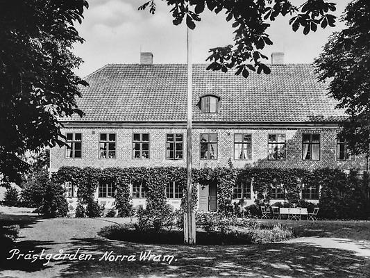Gammalt foto i svart och vit som beskriver ett ståtligt hus
